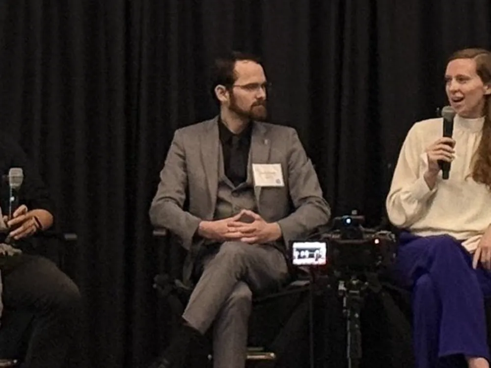 Holding a microphone while answering a question at an event.
